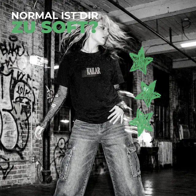 Frau im Kailar-Shirt vor einer Graffiti-Wand, dazu „Normal ist dir zu soft?“