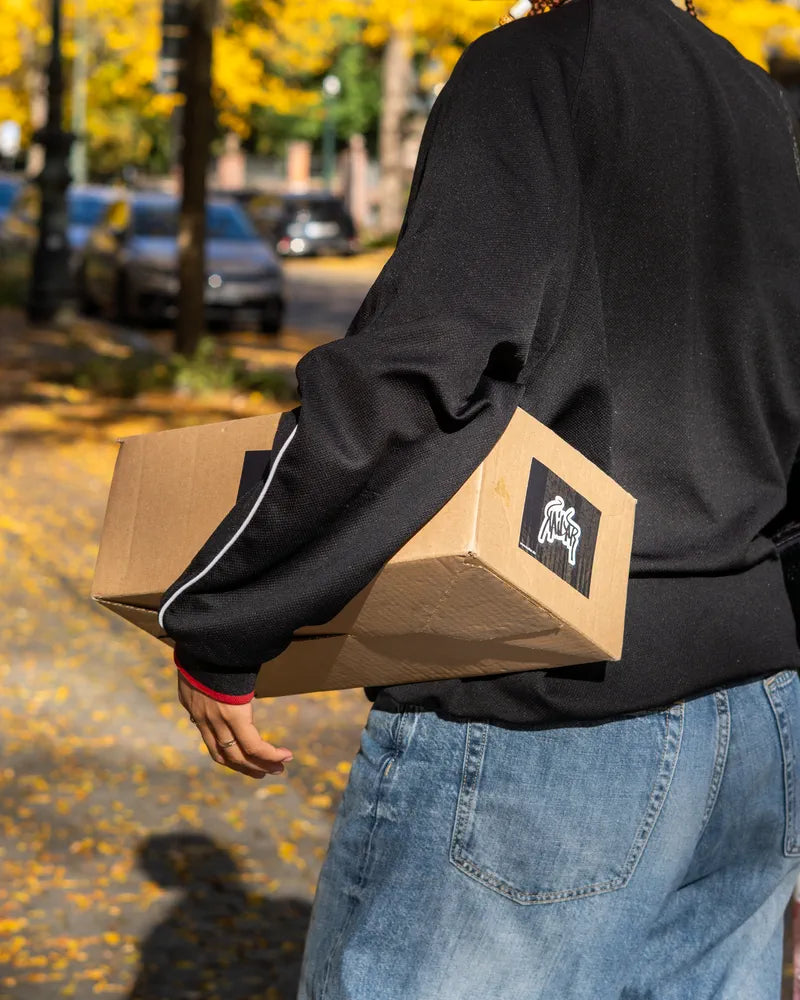 Jemand trägt ein Kailar-Paket unter dem Arm