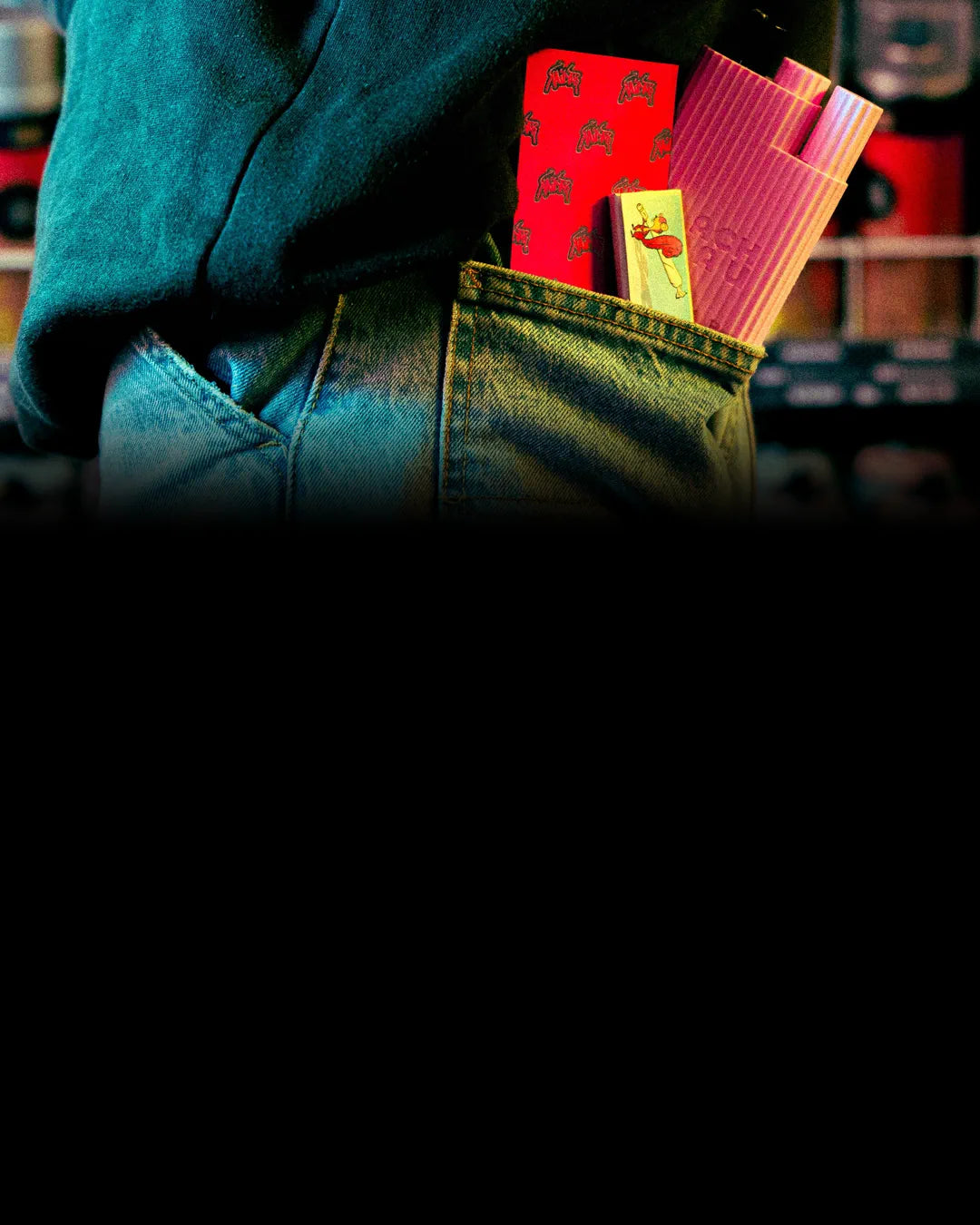 Kailar-Papers in Rot, Rosa und Gelb stecken hinten in der Jeanstasche