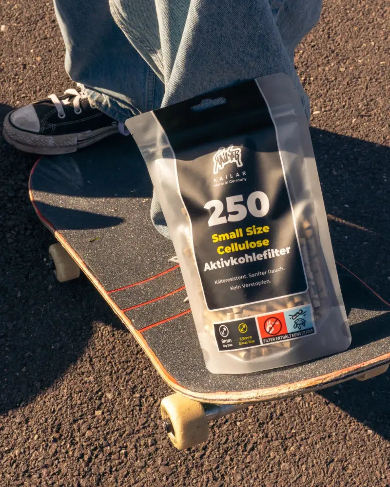 250er Soft-Packung auf einem Skateboard, daneben ein Turnschuh